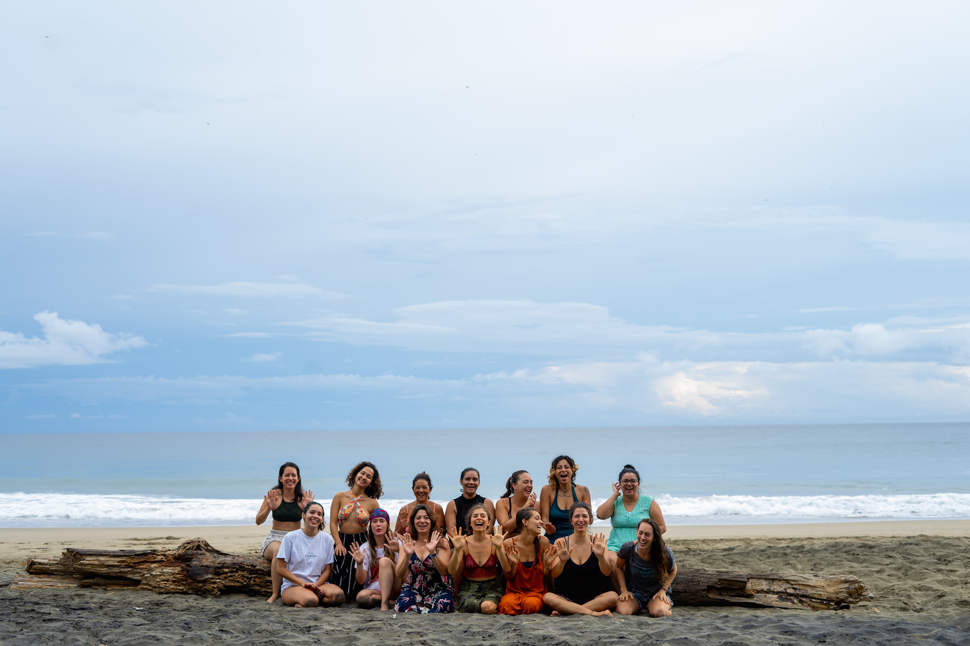 Retreat participants gathered on a beach — group photo at twilight.